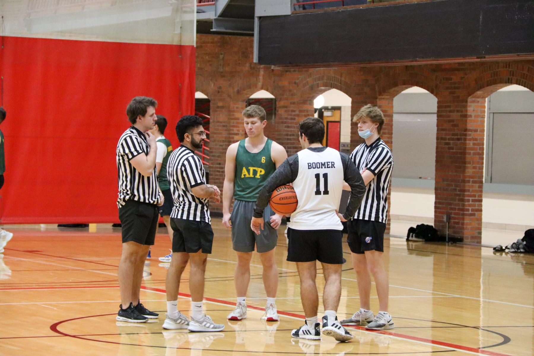 Basketball officials lead a captains meeting before an Intramural basketball game