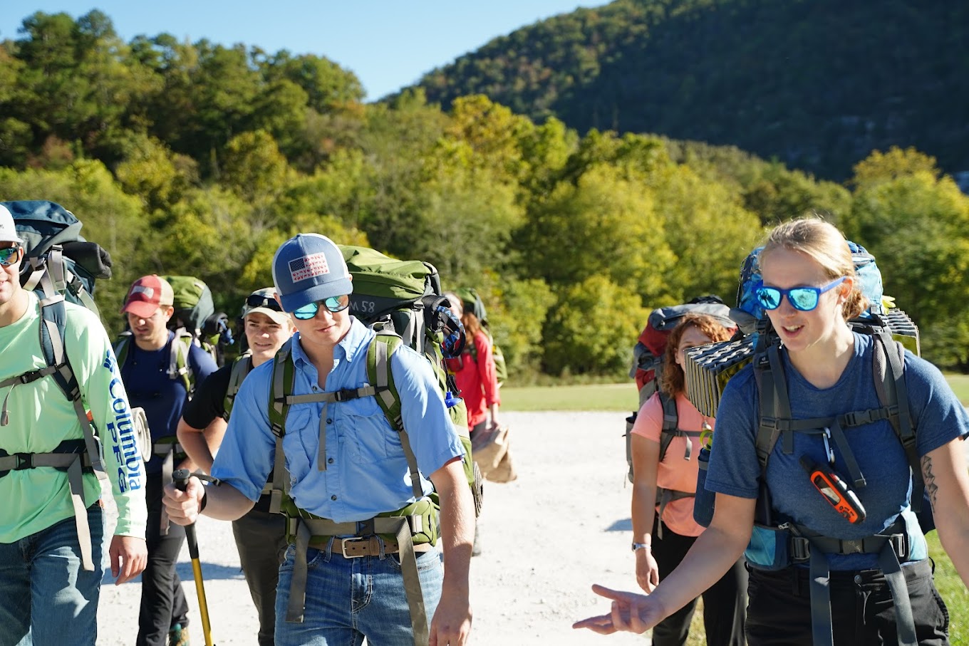 Individuals participate in a backpacking adventure trip