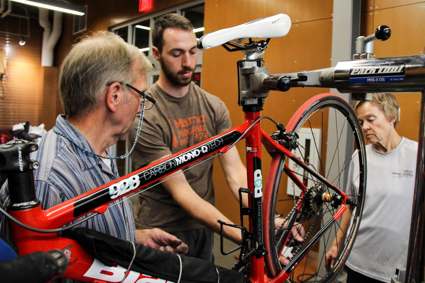 Bike Shop staff members demonstrates proper bike maintenance