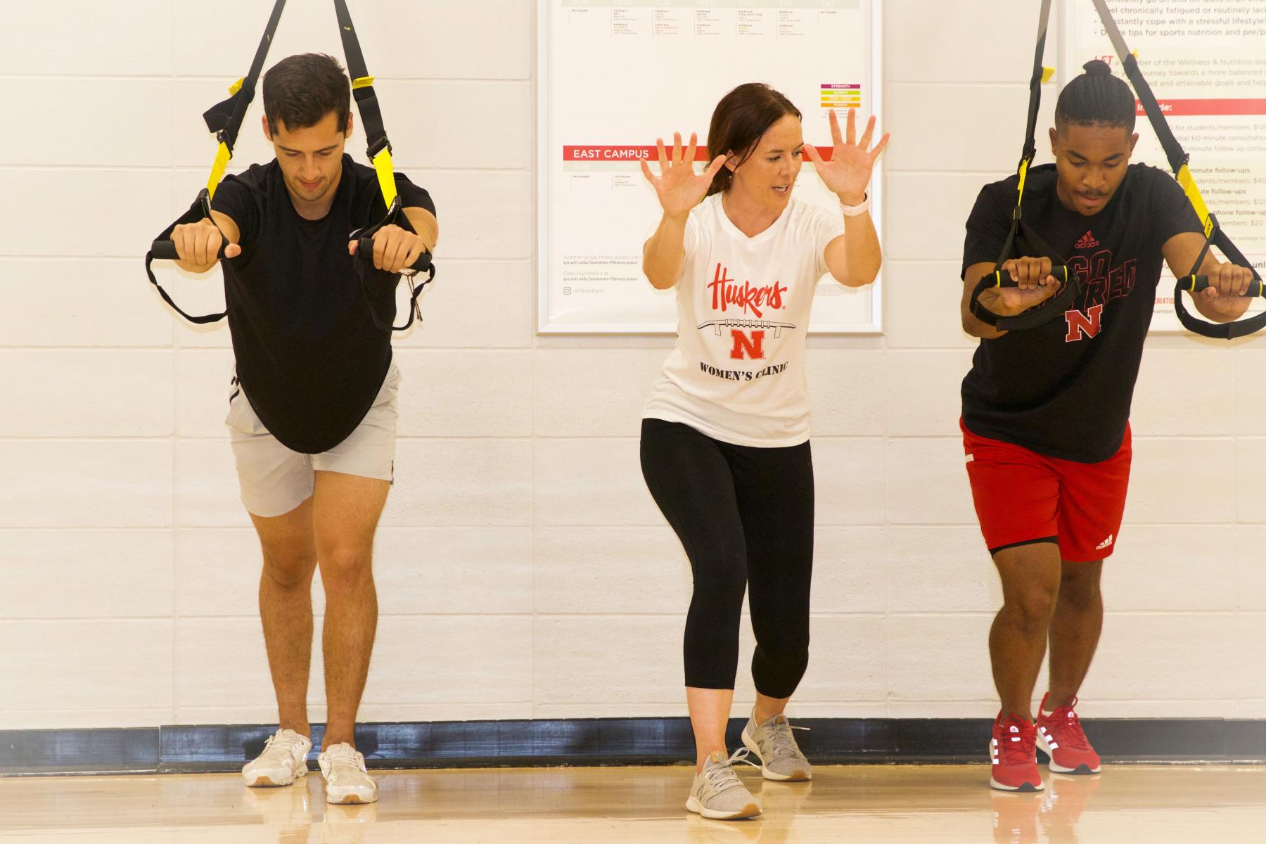 Participants work with a personal trainer on the TRX® apparatus