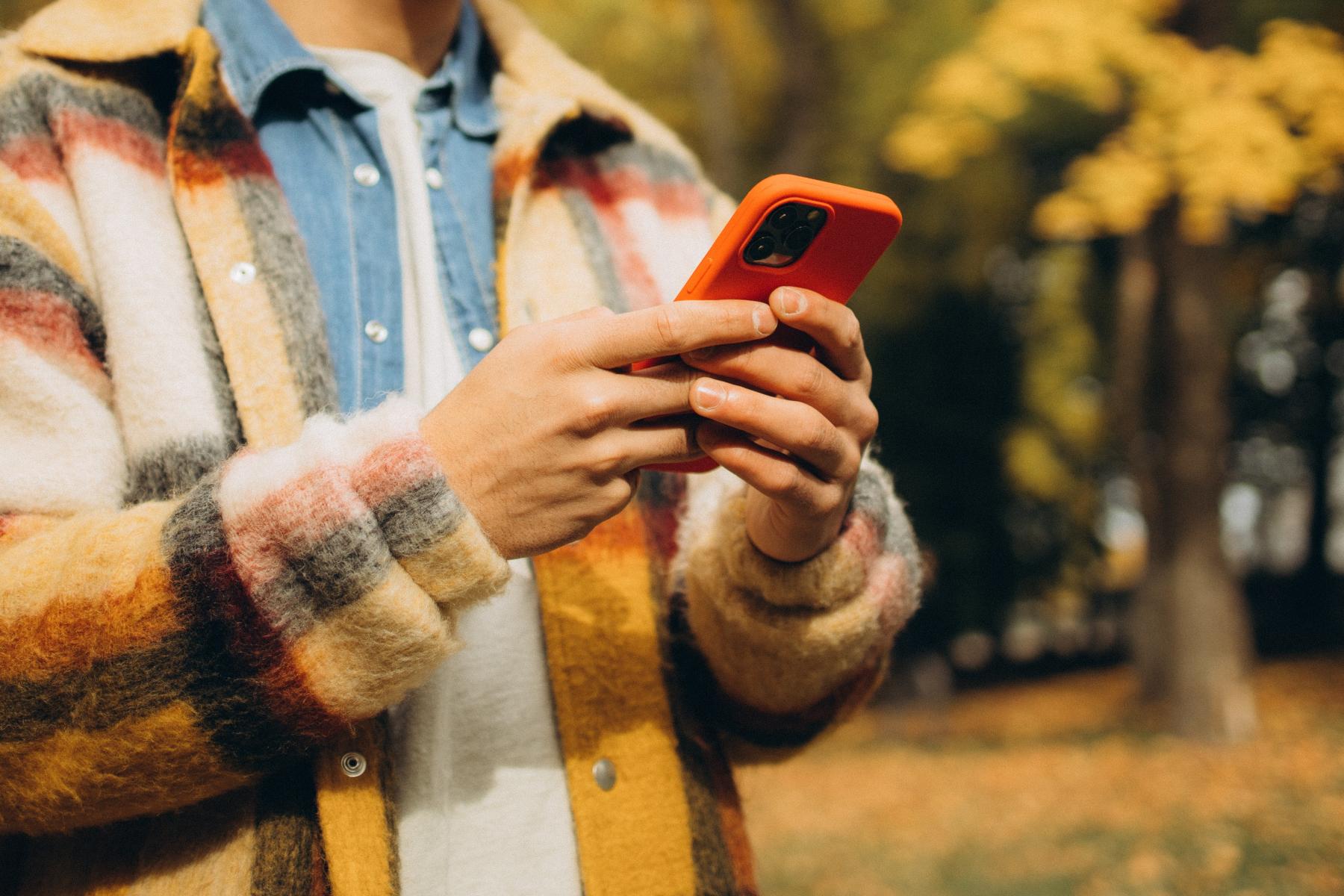 Person in warm long sleeve coat holding a phone