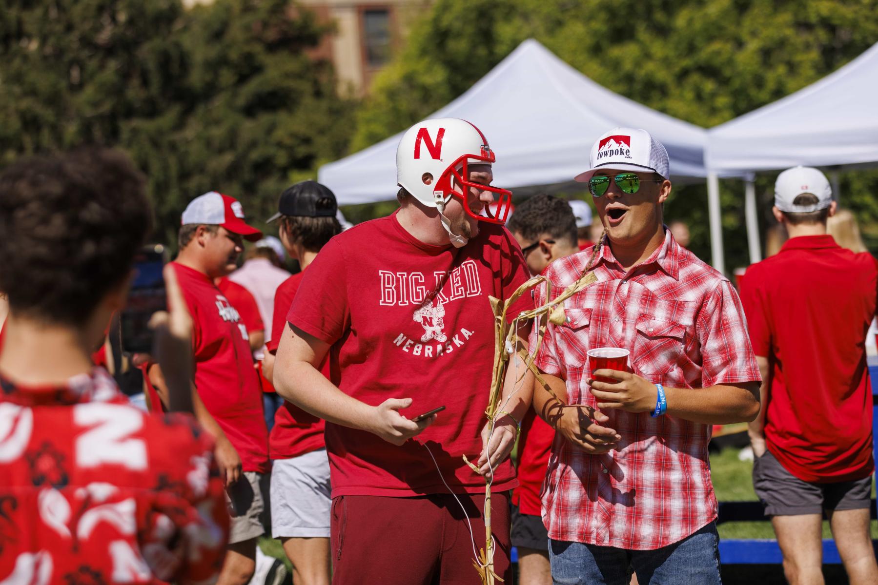 Students enjoy friendly conversation during a Husker Tailgate in the green space of the Nebraska Union