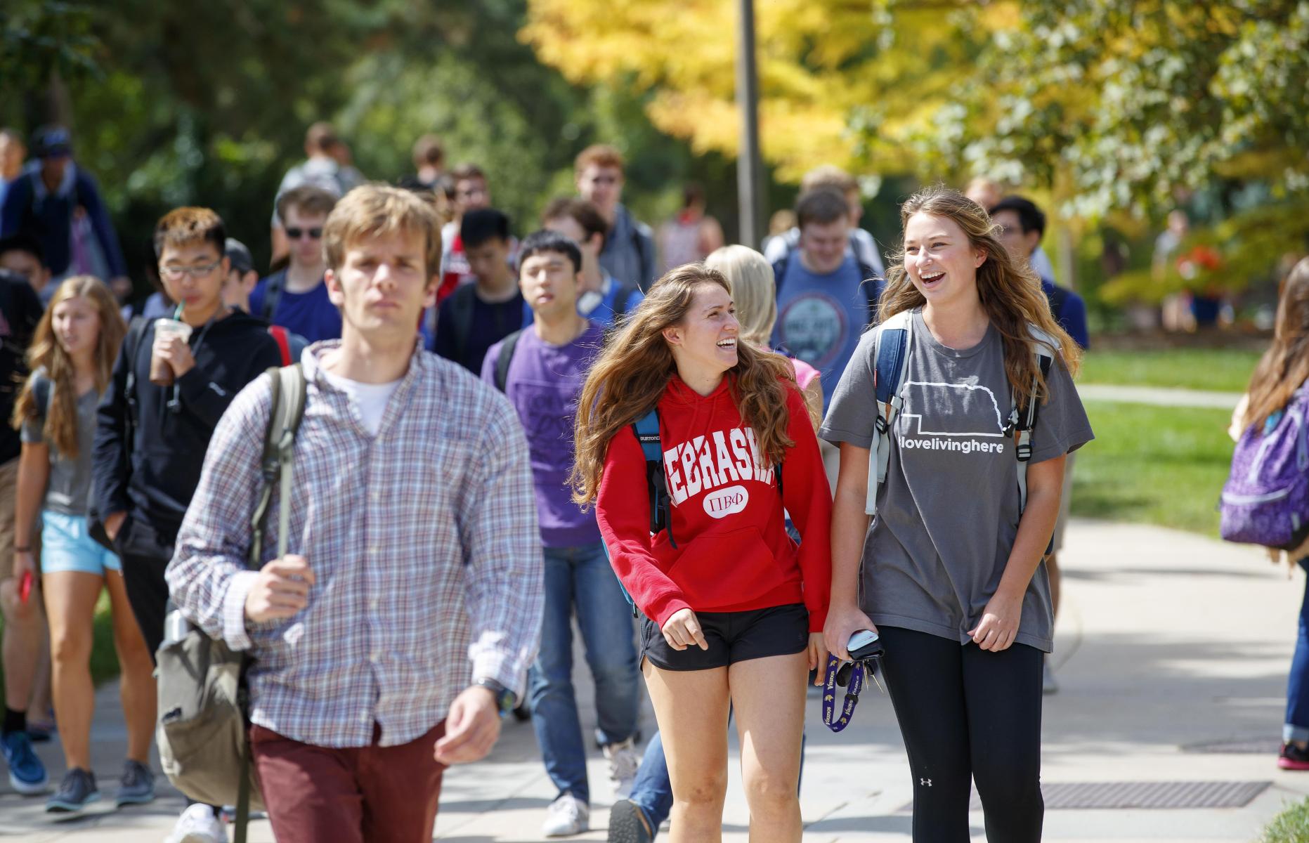 Students walk across campus enjoying conversation on a beautiful day