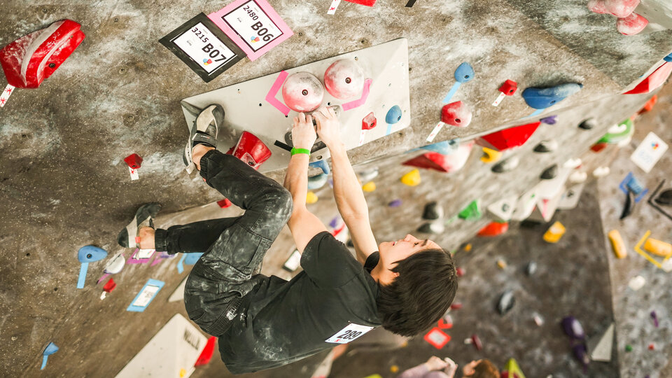 Person climbing on indoor rock wall.