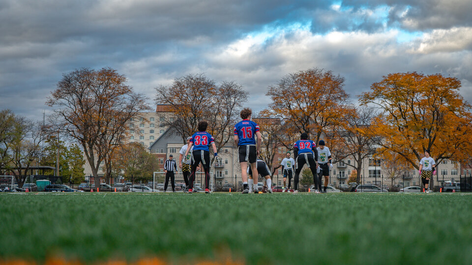 Flag football players before a play on a field