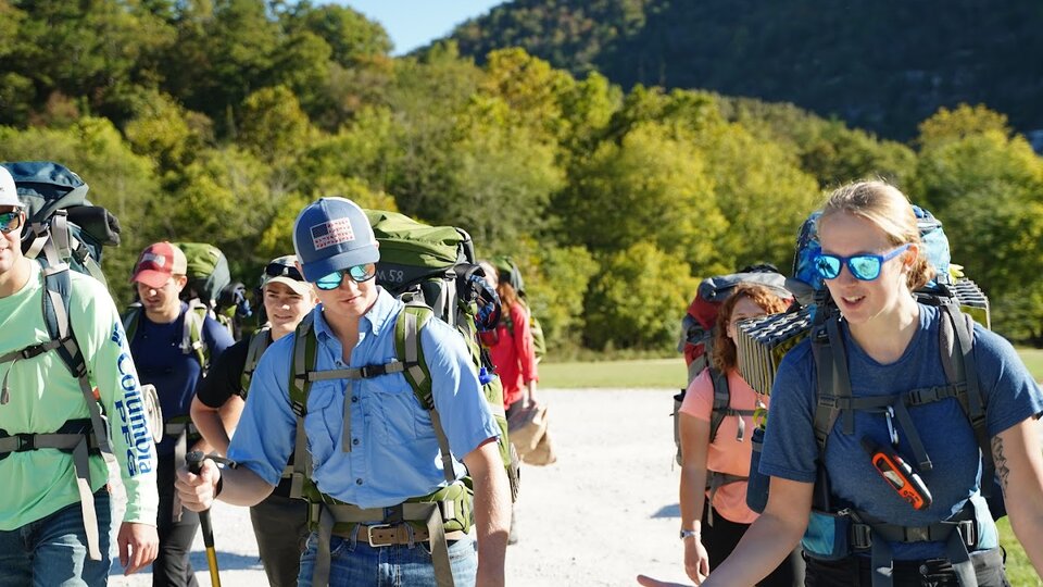 Individuals participate in a backpacking adventure trip