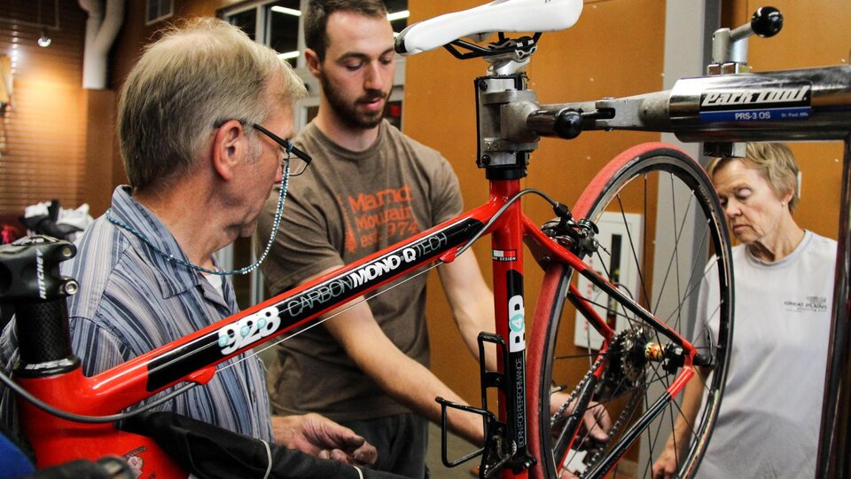 Bike Shop staff members demonstrates proper bike maintenance