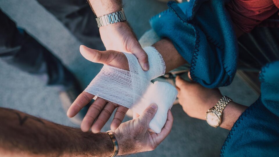 First aid is administered to an injured arm.
