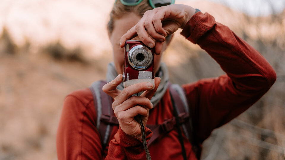 hiker with camera in hand taking photo
