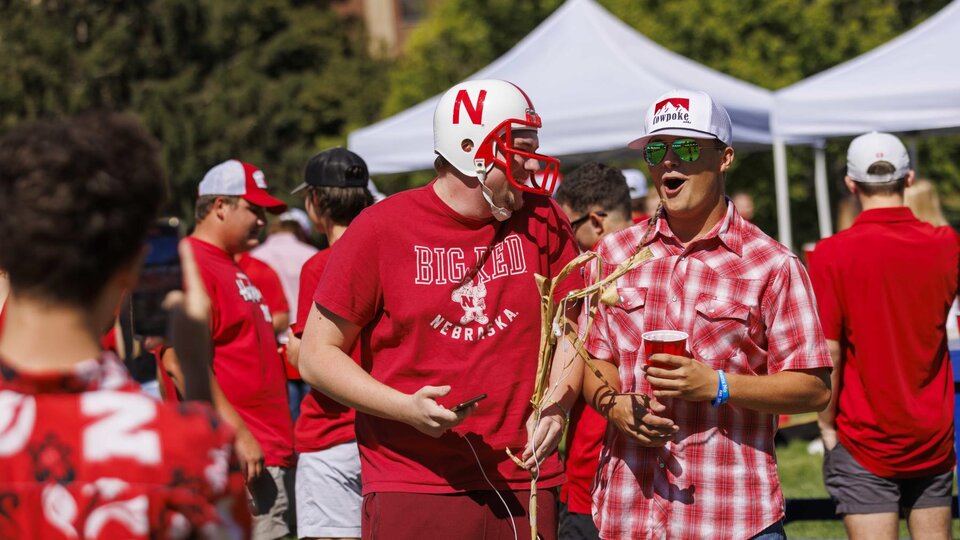 Students enjoy friendly conversation during a Husker Tailgate in the green space of the Nebraska Union