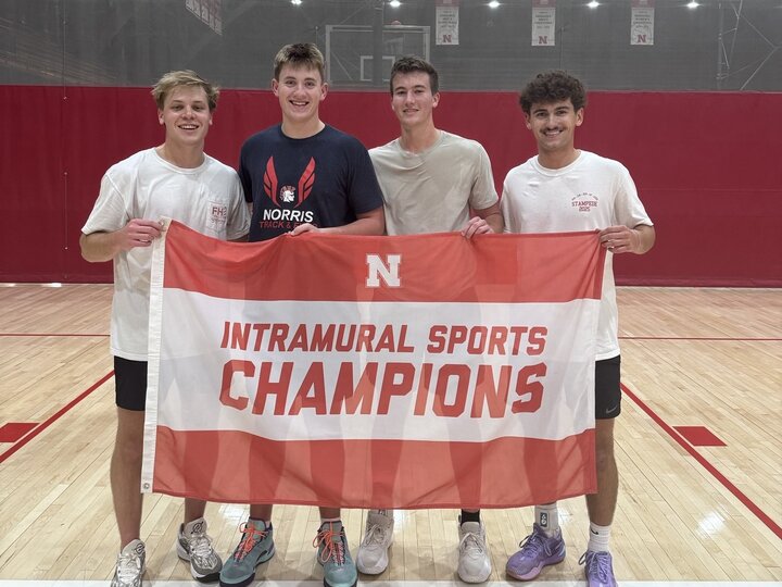 Students holding championship flag at the basketball court.