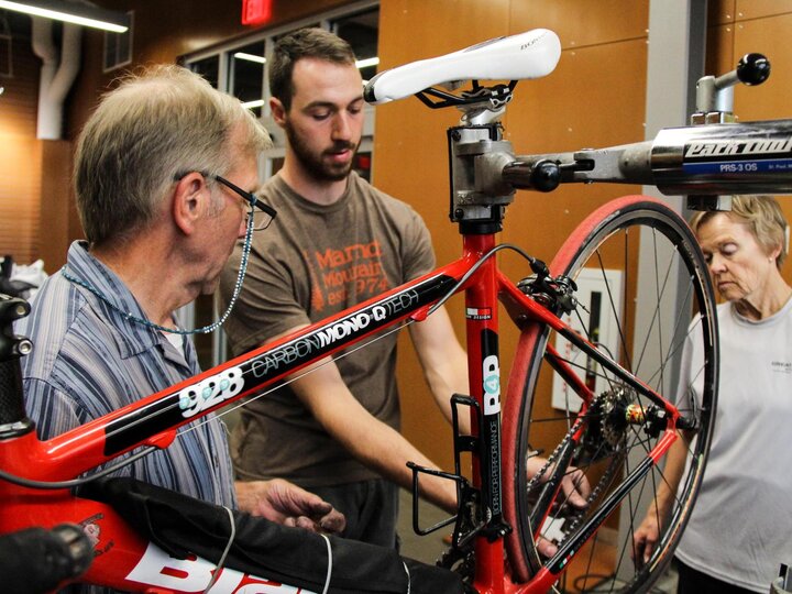 Bike Shop staff members demonstrates proper bike maintenance