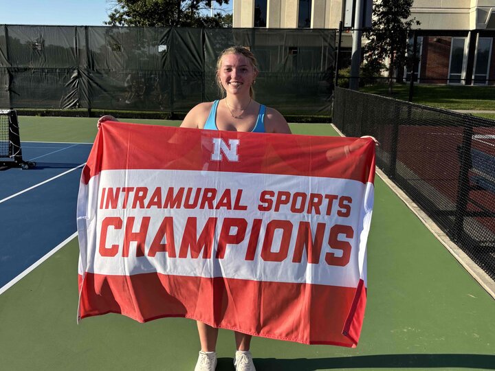 Student standing with flag.