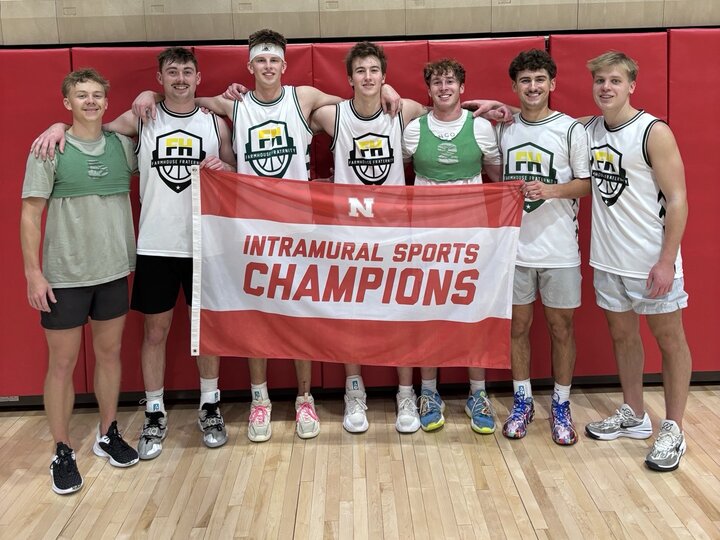 Group of athletes holding a red banner reading "Intramural Sports Champions" indoors.