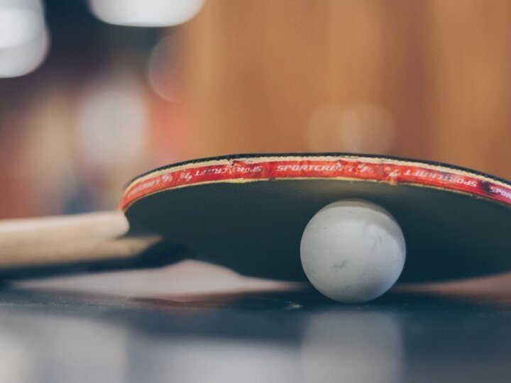 Table tennis paddle and ball on a table