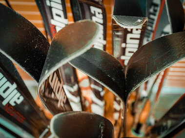 Rental snow skis sit in a container.