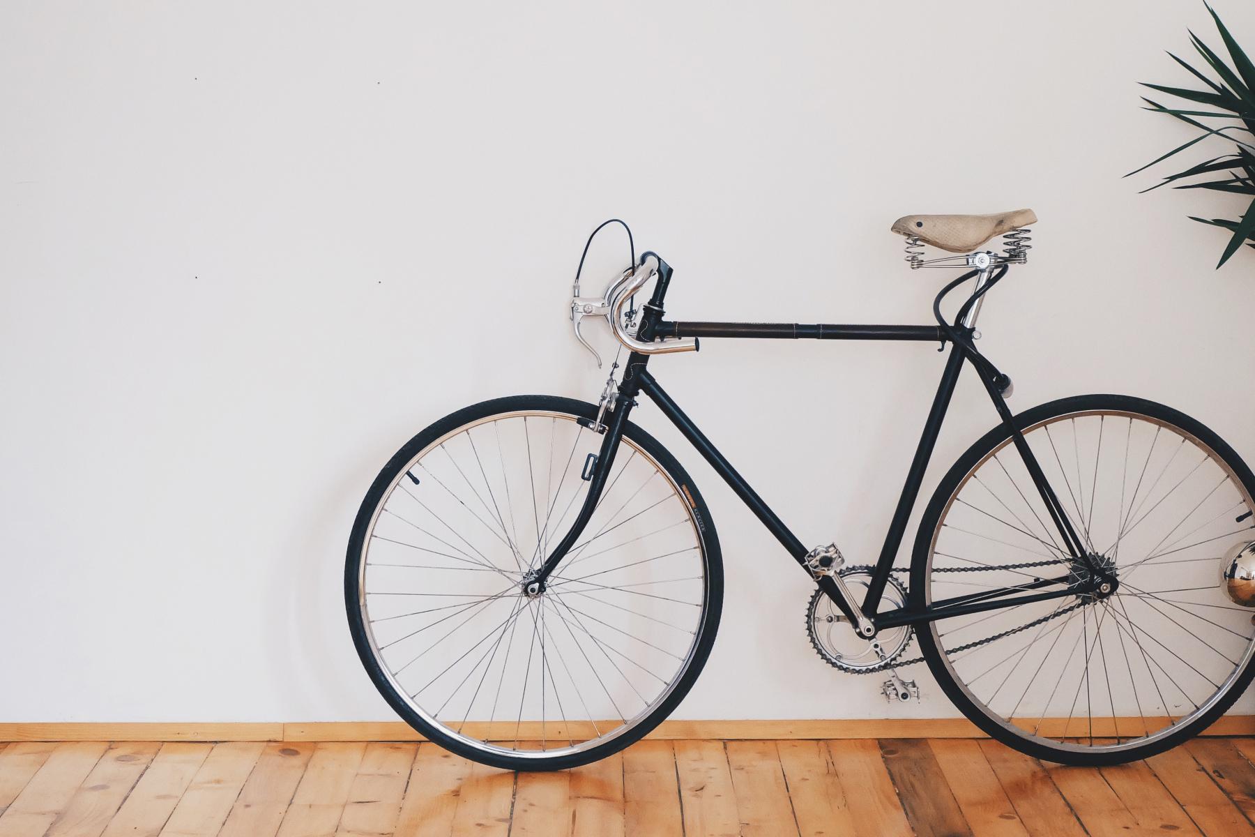 A bike sits against a wall.