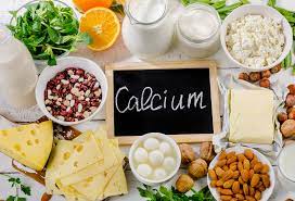 Calcium written on a chalkboard with calcium-rich food items around it