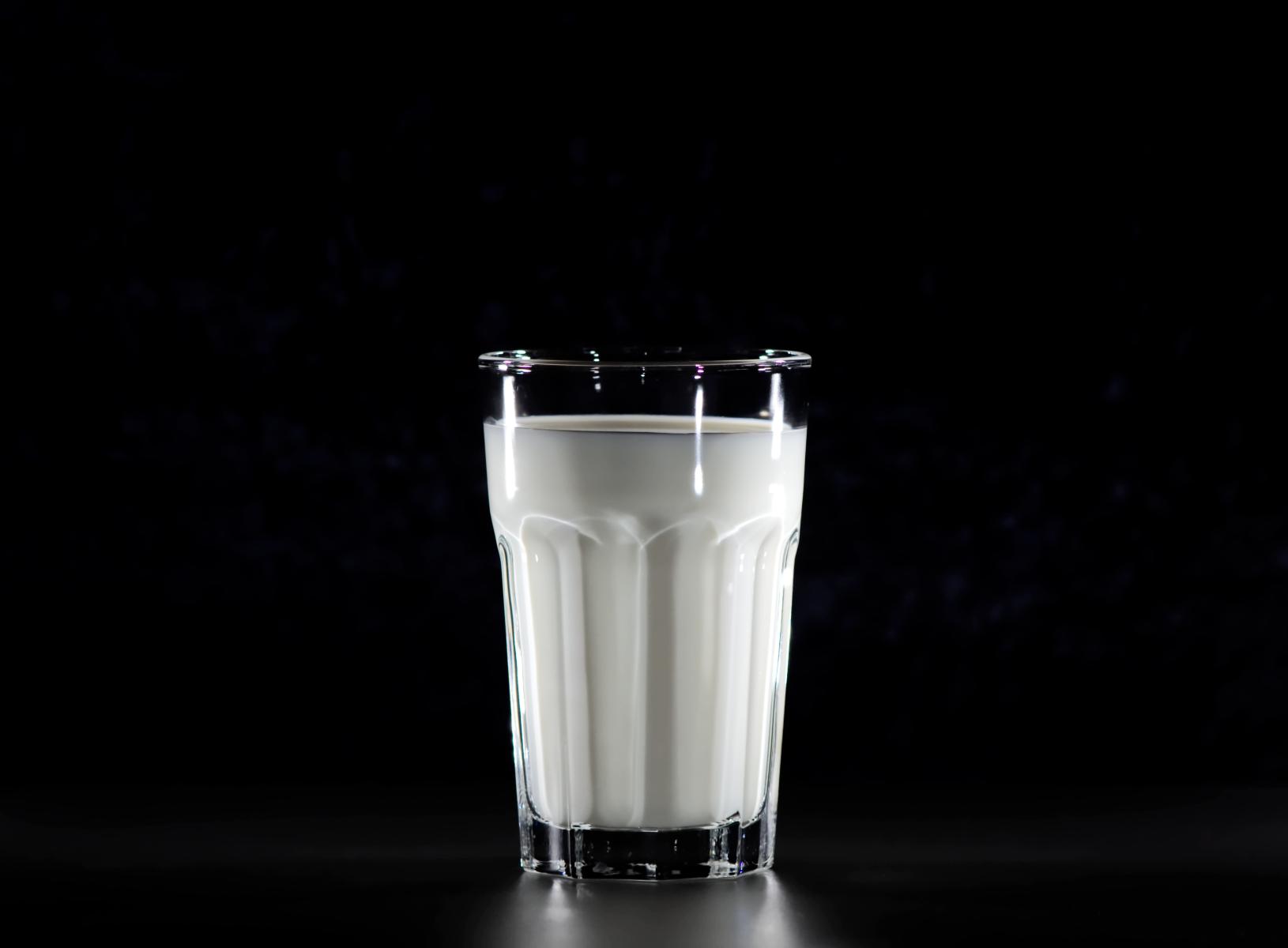 Milk in a glass on a black background